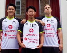 Drei Spieler des Handballverein Lüneburg in ihrem Trikots mit großen Lünestrom- und Sparkassen-Logos.